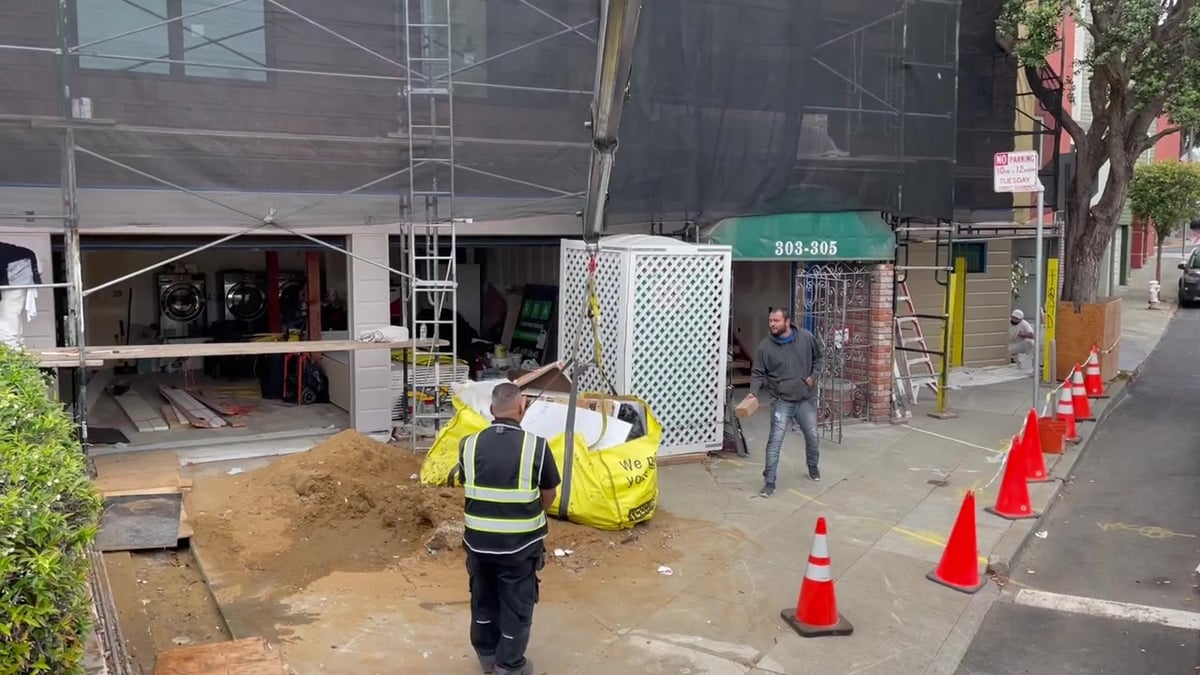 Three Yellowsacks on a construction site as the crane truck arrives