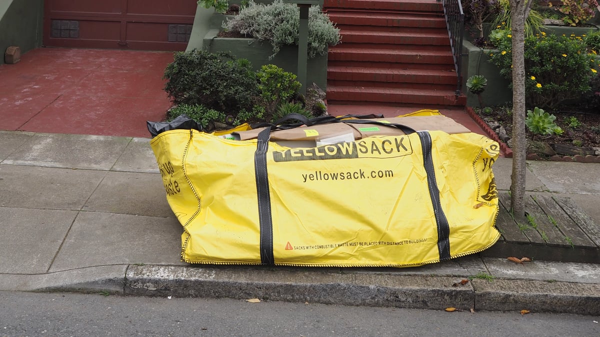 A filled Yellowsack dumpster bag on a driveway