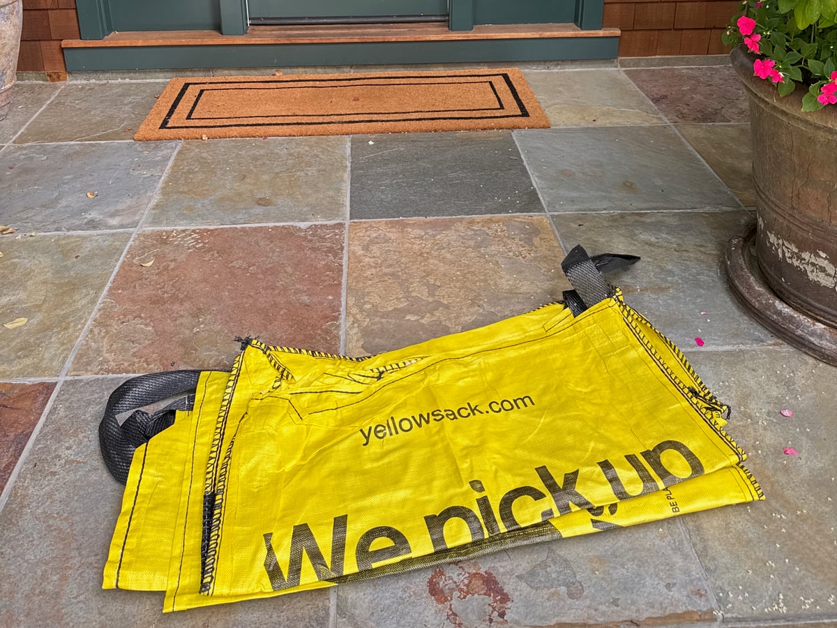 A folded-flat Yellowsack delivered on a doorstep