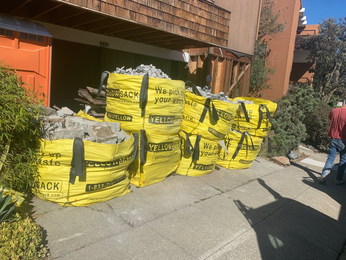 A Medium Yellowsack filled with broken concrete slab during a patio demolition