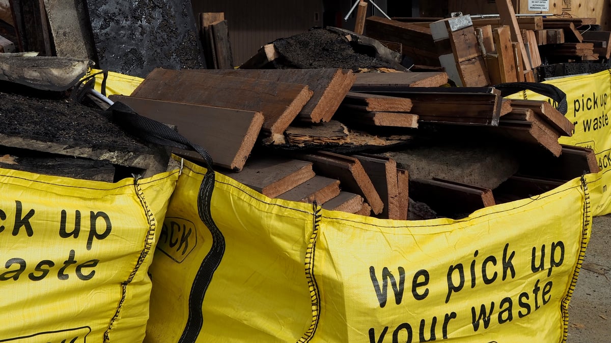 A Large Yellowsack filled with lumber on a jobsite